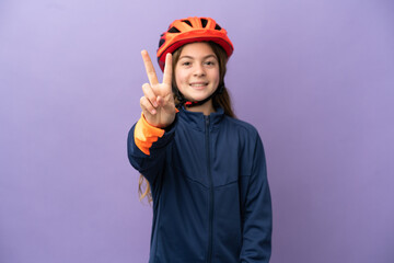 Little caucasian girl isolated on purple background smiling and showing victory sign