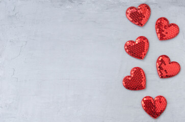 Shiny red hearts with sequins on a gray blue background. Template for design and text for Valentines Day with copy space