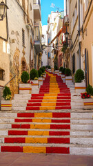Fototapeta na wymiar Escaleras pintadas con la bandera de España en una calle de Calpe en Alicante, España.