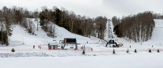 Skiers going down the slopes and taking the chairlift at Horseshoe ski resort in Barrie, Ontario,...