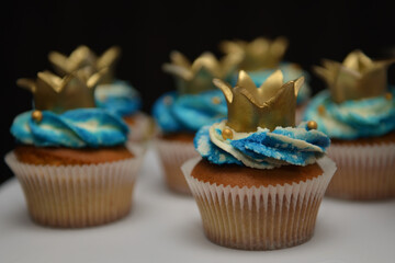 Cupcakes with colorful filling and golden crowns made of handmade sugar. Vanilla cupcakes with...