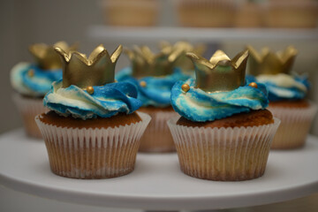 Cupcakes with colorful filling and golden crowns made of handmade sugar. Vanilla cupcakes with...