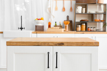 White counter with wooden table top in light kitchen