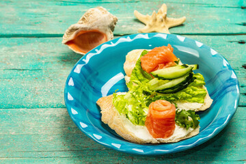 Open sandwiches with salted salmon, cream cheese, salad leaves and cucumber. Seafood, healthy food