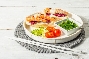 Open sandwiches with boiled shrimps, cream cheese, salad leaves, and Chuka salad. Seafood