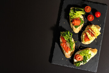 Assorted open sandwiches with salted salmon, cream cheese, salad leaves and cucumber. Seafood