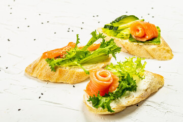 Open sandwiches with salted salmon, cream cheese, salad leaves and sesame seeds. Seafood