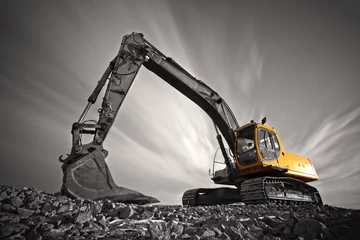 Fotobehang Vrachtwagen Excavator parked on stone ground against dramatic sky  © robin