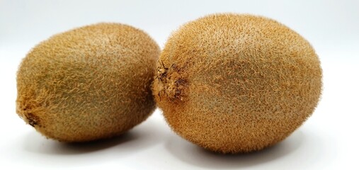 Two kiwi on a white background close-up. Ripe kiwi peeled on the table. Delicious kiwi fruit.