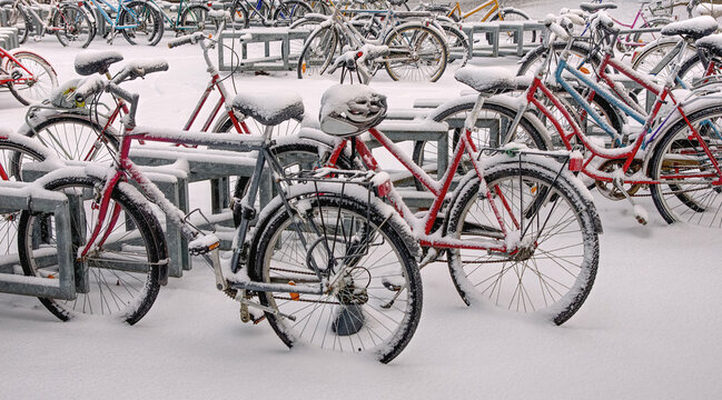 Bicycles under snow in a station bike park. Winter bicycling 