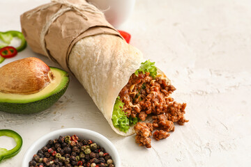 Tasty burrito and spices on light background