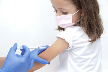 Criança tomando vacina no braço com prevenção do covid 19 e medico com luva azul e seringa na...