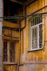 Obraz premium A corner of old building facade of typical houses in Odessacity center old town yards. Huge vintage windows, dirty scratched walls.