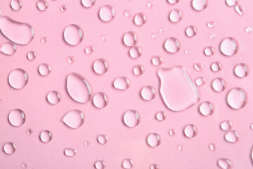 Many water drops on pink background, closeup
