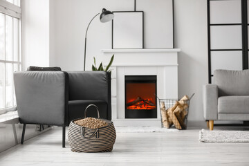 Bag with wood pellets near armchair in living room