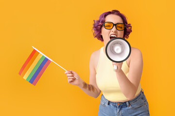 Young woman with LGBT flag and megaphone on yellow background