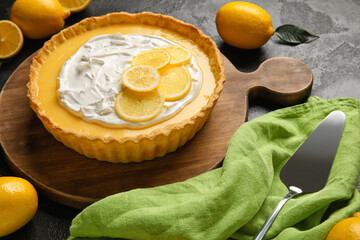 Board with delicious lemon tart on dark background