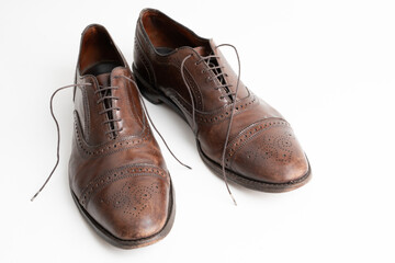 Studio shot of old, weary and little scratched cap toe lace op oxford shoes in burnished brown...