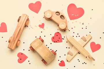 Wooden cars, airplane, paper hearts and confetti on beige background. Valentine's Day celebration