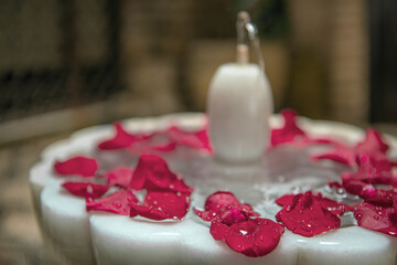 Beautiful scented rose petals in the bowl of a white marble fountain