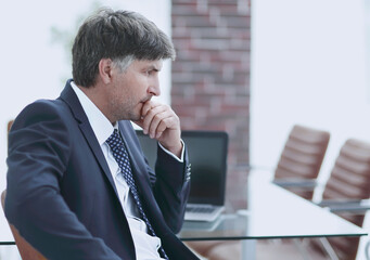 pensive businessman sitting at office desk in office