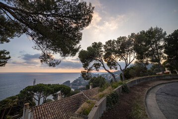Seascape. Mediterranean evening. Rocks surrounded by water on the beach protruding into the sea on a sunny day, Blanes, Catalonia, Spain.