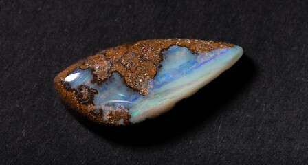 Colorful boulder opal gem from Winton Australia on black background