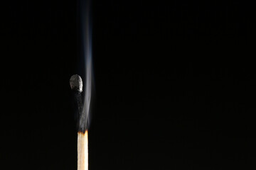 Fototapeta premium A match burned with an orange flame and produces heat 