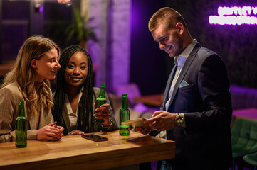 Cheerful colleagues drinking beer in the bar together after work