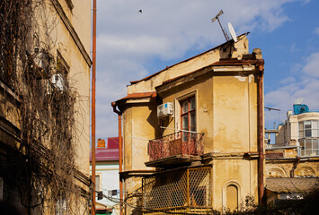 Fototapeta na wymiar Odessa, Ukraine - 04 24 21: A part of old building facade with windows and balcony. Typical houses in old town city center. Sunny spring photo