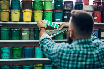 Male worker mixing colors for screen printing in a workshop