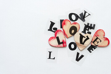 the word "love" composed of transparency type letters on paper with grungy hearts
