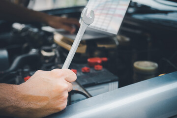 Close up hands of unrecognizable mechanic doing car service and maintenance.