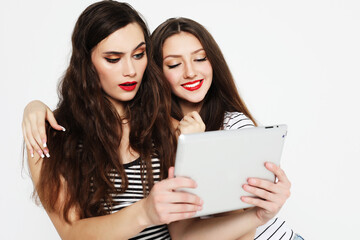 two girls friends taking selfie with digital tablet over white background