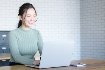  パソコンをタイピングする美しい日本人女性コピースペースあり