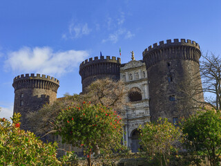 Blue sky, green trees and Castel Nuovo (New Castle), also called Maschio Angioino (Angevin Keep),...