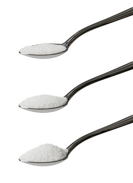 Set of three teaspoons of refined white sugar showing an angled view of level, rounded and heaped measurements isolated on a white background