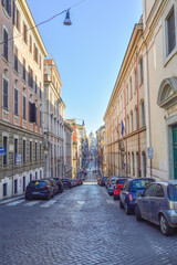 Paved road, old houses and blue sky in a sunny winter day on Via Panisperna in Rome, Italy