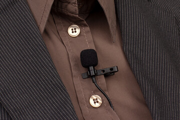 small audio microphone for voice recording with a clothespin attached to a woman's shirt.