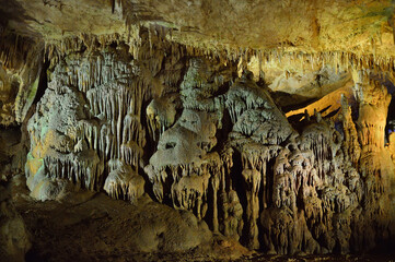 Prometheus cave formations in Georgia. Limestone stalactites and stalagmites in colourful illumination. Underground world of caucasian mountains