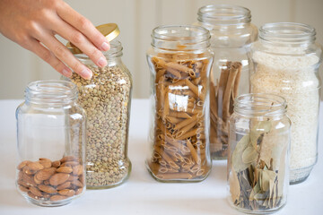 Hand closing glass jars containing food