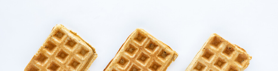 Narrow view of plain homemade whole grain waffles against a white background.
