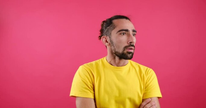 Impatient man waiting with arms crossed over pink background