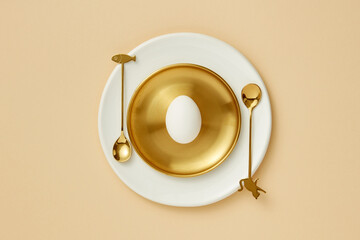 Flatlay of Easter egg on golden plate