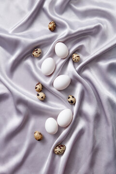 Flatlay of quail and chicken eggs on silk cloth