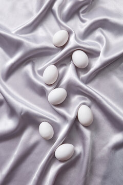 Flatlay of chicken eggs on silk cloth