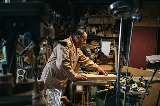 Focused craftsman working on jointer