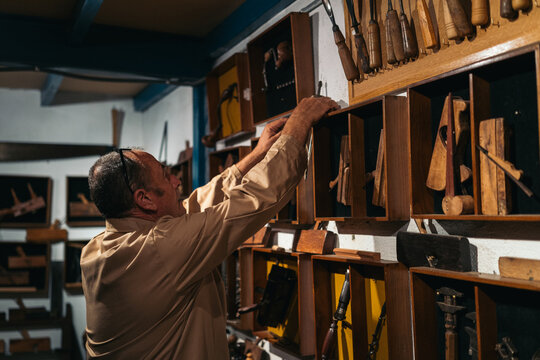 Carpenter taking jointer from shelf