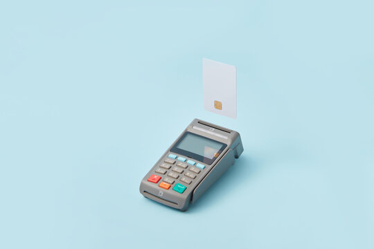 Terminal and credit card on light blue background
