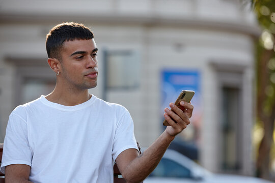 Young Indigenous Australian man using mobile phone outdoors